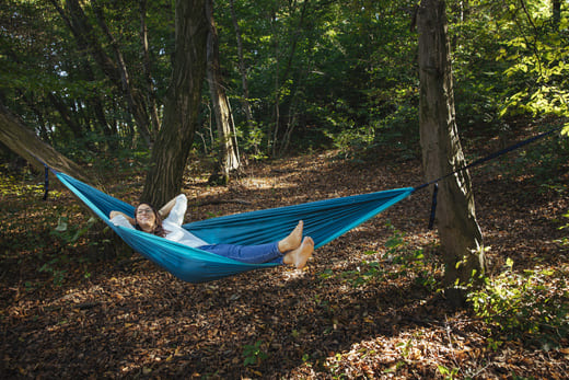 Klientin liegt beim Coaching in Wien in der Hängematte im Wald